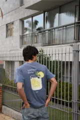 Remera de algodón 100% peinado color negro con efecto gastado, de corte recto y manga corta. Presenta un estampado gráfico en la espalda con diseño pixelado de un vaso con limonada, rodajas de limón, hojas de menta y la inscripción "summer flavor".