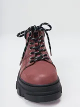 Bota acordonada de estilo montañés con suela track de goma robusta. Confeccionada en cuero con detalles de gamuza en la talonera y tirador trasero. Presenta costuras a contratono y cordones bicolores.