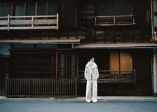 Parka de corte recto en mezcla de lana color blanco, con cuello embudo grande, mangas largas con trabillas, dos bolsillos de solapa laterales y cierre delantero con botones.