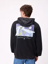 Canguro con capucha de color negro con efecto lavado, manga larga y bolsillo frontal. Presenta un estampado gráfico en la espalda con el logo de la marca y motivos abstractos en tonos violeta y amarillo.