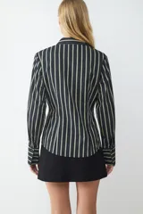 Camisa de manga larga con estampado de rayas verticales en tonos verde claro y negro. Presenta un corte ajustado (slim fit), cuello clásico, cierre frontal de botones y puños anchos a rayas.