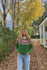Sweater de lana merino con estampado Fair Isle en tonos azul marino, beige, naranja, verde oliva y bordó. Tiene cuello redondo y mangas largas.