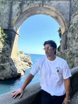 Remera blanca de algodón con cuello redondo y estampado en la espalda con imágenes de cogollos de marihuana y texto "BROKERS HIGH QUALITY GOODS".