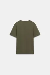 Camiseta de algodón con efecto lavado, cuello redondo y manga corta. Presenta un detalle de fornitura metálica aplicada en el pecho.