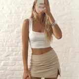 Top corto blanco con escote cuadrado y tirantes anchos, confeccionado en tela elastizada.