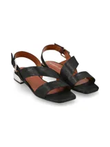 Sandalias de cuero negro con textura sutil, tiras asimétricas cruzadas, tira ajustable al talón con hebilla metálica y taco bajo cuadrado con acabado metálico plateado.