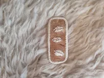 Broche para pelo artesanal de cuero con bordados en tiento fino.