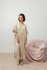 Vestido camisero largo color beige claro, con cuello mao, botones frontales y mangas cortas abullonadas con detalle bordado.