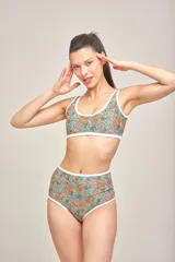 Conjunto de bikini con corpiño triangular estampado con motivos geométricos y bombacha tiro alto color verde liso.