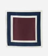 Pañuelo cuadrado de tejido satinado con estampado geométrico en tonos azul marino, bordó y blanco. Presenta una caída fluida y versátil para usar en el cuello, cabello o como accesorio.