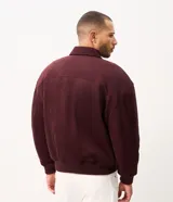 Campera bomber Marfinno para hombre, de gamuza sintética (suede) color tostado, con cuello camisero, cierre frontal metálico, bolsillos frontales y terminaciones en rib en puños y ruedo.