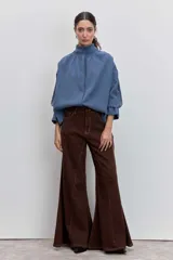 Camisa azul de manga larga con cuello alto fruncido y puños elásticos.