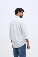 Camisa de manga larga color rosado, con cuello abotonado, cierre frontal de botones y un bolsillo ojal en el pecho.