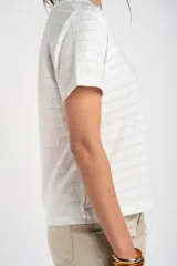 Remera blanca con cuello en V y mangas cortas, confeccionada en algodón con textura ligera y sutiles líneas horizontales.