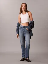 Jeans mom fit de tiro alto y pierna cónica, en denim azul con efecto deslavado. Cuenta con diseño clásico de cinco bolsillos, cierre de botón y cremallera, y detalles distintivos de la marca Calvin Klein.