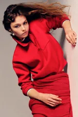 Jersey polo de punto liso color rojo, con cuello solapa, manga larga y bolsillo de plastrón en el delantero. Cierre frontal con botones.