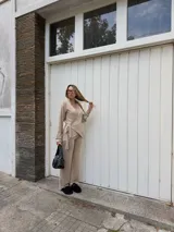 Saco tipo cardigan cruzado de lanilla color beige, con mangas largas y lazo ajustable en la cintura.