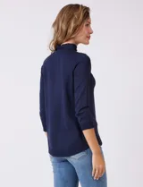 Buzo azul marino de tejido acanalado, con cuello alto tipo mock neck y mangas tres cuartos.