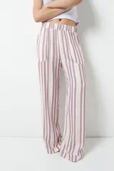 Pantalón de pijama celeste con rayas verticales finas color marrón, con bolsillos laterales y elástico en la cintura.