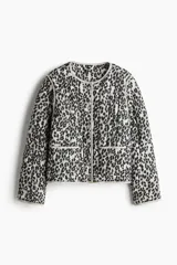 Campera acolchada de algodón con diseño guateado y estampado de leopardo. Presenta cuello redondo, cierre frontal con botones a presión, hombros caídos y bolsillos delanteros de parche con ribetes en contraste.