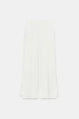 Pantalón de tiro medio de ZARA Woman Collection confeccionado en hilatura de viscosa. Cuenta con cintura con trabillas, bolsillos laterales, raya planchada y pierna recta con bajo asimétrico y aberturas. Cierre frontal con cremallera, botón y ganchos metálicos.