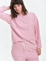 Buzo de dormir de tela acanalada con diseño de rayas horizontales blancas y rosadas. Presenta cuello redondo, hombros caídos y corte holgado, ofreciendo una silueta relajada y cómoda.