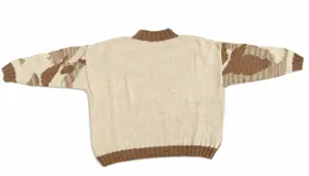 Buzo tejido a mano con diseño jacquard orgánico de formas inspiradas en el ceibo en tonos marrón, beige y blanco. Cuenta con cuello alto y terminaciones en rib.