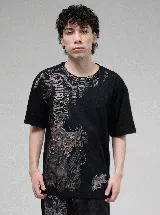 Remera negra de corte regular con cuello redondo y estampado frontal de estilo gótico con motivos de cruces y alas en tonos tierra y gris.