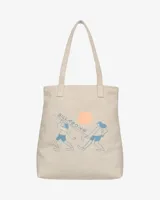 Tote bag Billabong de lona color beige con diseño estampado de la colaboración con Ty Williams que muestra figuras cargando una tabla de surf y un sol rosado.