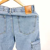 Pantalón jean celeste de corte recto con múltiples bolsillos cargo en los laterales y en la parte delantera.