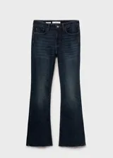 Jeans de tiro medio con corte flare y bajo deshilachado. Presentan diseño de cinco bolsillos, cierre frontal con cremallera y botón, y trabillas para cinturón.