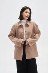 Tapado de paño color gris, con cuello camisero, cierre frontal de botones y bolsillos laterales con solapa.