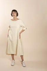 Vestido midi acampanado de lana fina sin teñir, con cuello bote, mangas tres cuartos con tajo y bolsillos laterales. Diseño forrado con vuelo y movimiento.