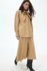 Pollera midi de corte A con tejido texturizado, cintura alta elástica con frunces y costuras verticales visibles en la parte frontal y posterior.