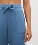Pantalón jogger deportivo de modal color azul, con cintura elástica ajustable con lazo, bolsillos delanteros aplicados, costuras frontales decorativas y puños elásticos en los tobillos.
