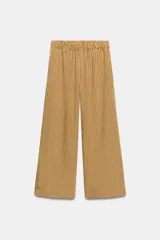 Pantalón de tiro medio con pierna ancha y cintura elástica, confeccionado en mezcla de viscosa con diseño de rayas verticales en tonos mostaza y marrón.