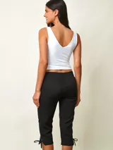 Musculosa negra de tirantes anchos con pronunciado escote en V tanto en la parte delantera como en la espalda, de corte ajustado y diseño liso.