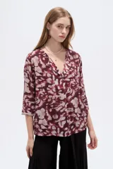 Blusa de viscosa bordó con estampado abstracto, escote en V con cuello tipo solapa y mangas 3/4, de corte holgado.