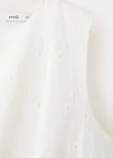 Vestido midi blanco sin mangas con diseño evasé y detalle de bordado inglés en toda la prenda.