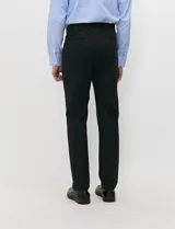 Ambo slim fit negro confeccionado en tejido tecnológico elastizado, compuesto por blazer estructurado y pantalón de vestir de corte recto.