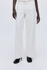 Pantalón de jean blanco de tiro alto, pierna ancha y corte holgado. Presenta bolsillos parche delanteros y traseros, y un detalle de ribete trenzado decorativo en la cintura.