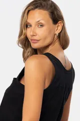 Musculosa blanca sin mangas, de corte clásico y calce cómodo, confeccionada en tejido suave. Presenta escote redondo, cartera con botones frontales y un pequeño bolsillo aplicado en el pecho.