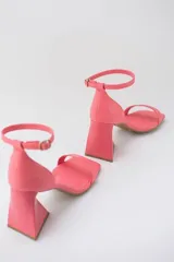 Sandalias color crema con tira delgada sobre los dedos, pulsera al tobillo con hebilla y taco geométrico.