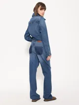 Pantalón de jean azul de corte recto, tiro medio y diseño estampado simulando bolsillos traseros. Incluye cinturón fino del mismo material.