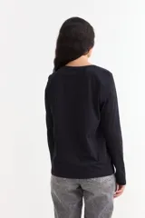 Remera de manga larga color beige con cuello redondo a la base. Presenta un estampado frontal con un dibujo de labios en color fucsia y la palabra 'BESITO' en color negro.