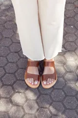 Sandalias de cuero marrón Austera modelo Parma, hechas a mano en Uruguay, con doble tira ancha sobre el empeine y suela plana.