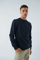 Buzo blanco de algodón con cuello redondo, mangas largas y logo y arte en relieve en el frente.