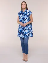 Túnica de gasa negra con estampado floral en tonos azules y blancos, cuello camisero, manga corta y cierre frontal de botones.