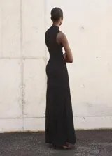 Vestido largo negro de punto fino, con cuello perkins y diseño sin mangas. Presenta un diseño entallado en la parte superior y falda evasé combinada de lyocell.