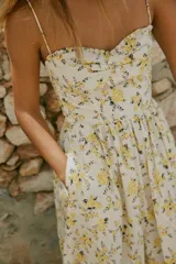 Vestido midi de popelín con estampado floral, escote corazón con volantes y tirantes finos ajustables. Cuenta con bolsillos laterales ocultos, detalle de tablas en el pecho y abertura en la espalda con lazada. Incluye forro interior.